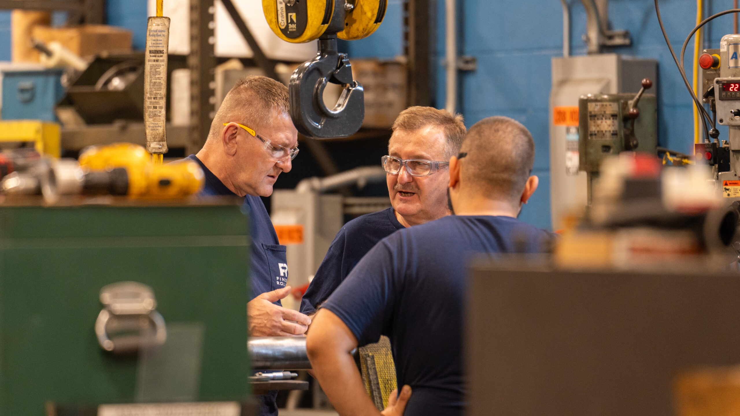 Three men talking in manufacturing settings